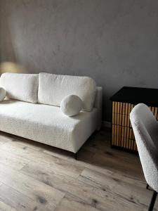 a living room with a white couch and a table at Loft Re Design Apartament in Głogów