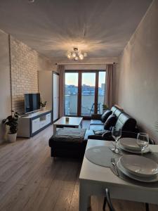 a living room with a couch and a tv at Apartments Space and More, Dmowskiego - 20 minut do RYNKU, Self Check-In 24H, Parking in Wrocław