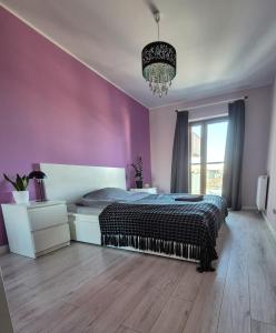 a bedroom with a bed and a chandelier at Apartments Space and More, Dmowskiego - 20 minut do RYNKU, Self Check-In 24H, Parking in Wrocław