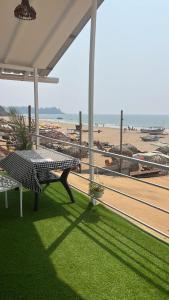 a patio with a table and a view of the beach at Casa fiesta patnem in Patnem