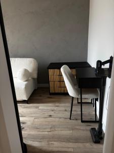 a desk with a chair and a bed in a room at Loft Re Design Apartament in Głogów