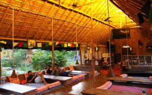 a group of people sitting on couches in a building at Rocky Meadows Resort Hampi in Hampi