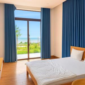 une chambre avec un lit et une grande fenêtre dans l'établissement Tiến Hưng Tam Thanh Villa, à Phú Quí (2)