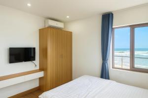 une chambre avec un lit, une télévision et une fenêtre dans l'établissement Tiến Hưng Tam Thanh Villa, à Phú Quí (2) 29 autres photos