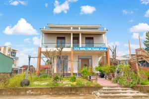 un bâtiment blanc avec un panneau bleu dessus dans l'établissement Tiến Hưng Tam Thanh Villa, à Phú Quí (2)