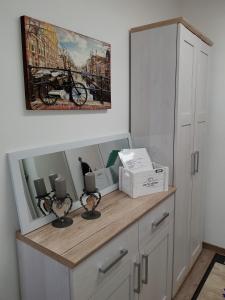 a white cabinet with a picture on the wall at Charmante Wohnung In Langfurth Mit Kleinem Balkon in Schöfweg