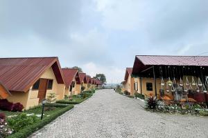 a cobblestone street between two buildings with red roofs at Urbanview Hotel Nerine's Glamping Village Cipanas by RedDoorz in Barukupa