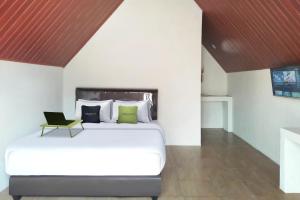a bedroom with a bed with a laptop on it at Urbanview Hotel Nerine's Glamping Village Cipanas by RedDoorz in Barukupa