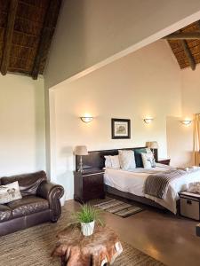 ein Schlafzimmer mit einem großen Bett und einer Couch in der Unterkunft ParkView Safari Lodge in Colchester