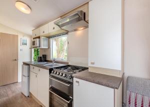 eine Küche mit Herd und Spüle in der Unterkunft Foxhunter Park in Minster + 15 Fotos