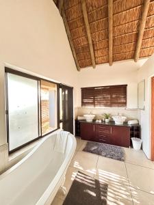 ein Badezimmer mit Badewanne und großem Fenster in der Unterkunft ParkView Safari Lodge in Colchester