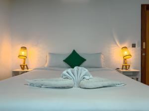 a bed with a white blanket and two lamps at Studio Marvel Canggu in Dalung