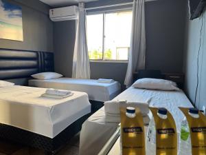 a room with two beds and two bottles of bleach at Pecém Hotel in Pecém