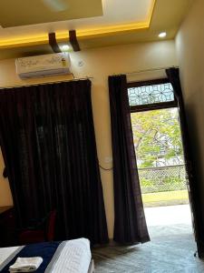 Un dormitorio con una ventana y una cama con cortinas negras. en Shri Homes, en Varanasi 15 fotos más