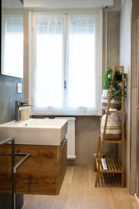une salle de bain avec un lavabo blanc et une fenêtre dans l'établissement ELIOS LIVING - Modern comfort, private parking, near center & 200m from the beach, à Bordighera