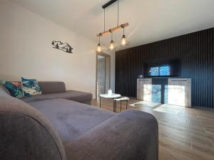 Una sala de estar con un sofá y un televisor en Chata Pri Potoku 2, en Valča