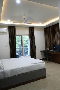 Ένα ή περισσότερα κρεβάτια σε δωμάτιο στο The President Hotel, Tumkur