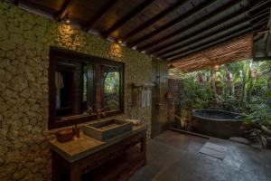 ein Badezimmer mit Waschbecken und Badewanne in der Unterkunft Aksmi Suites & Villas in Bedahulu + 25 Fotos