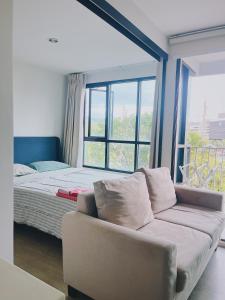 プーケットタウンにある02Nice room phuket town near Shopping Malls and Naka night marketのソファと大きな窓のあるリビングルーム