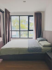 een bed in een kamer met een groot raam bij 02Nice room phuket town near Shopping Malls and Naka night market in Phuket +26 foto's