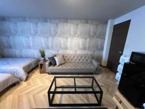 a living room with a couch and a coffee table at ペット可最大6名福井駅徒歩20分民泊 ピーチジョー足羽 in Fukui