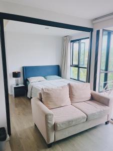 a living room with a couch and a bed at 02Nice room phuket town near Shopping Malls and Naka night market in Phuket Town