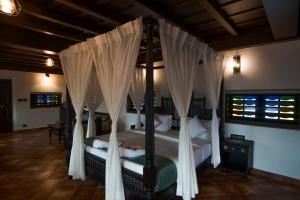 Un dormitorio con una cama con dosel y cortinas blancas. en SVS Arena, en Kodali