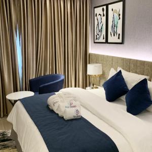 una camera d'albergo con un grande letto con cuscini blu di Blu Pearl Hotel & Residence a Benin City