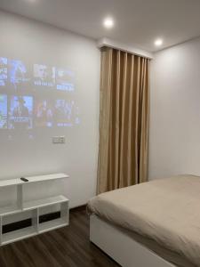 a bedroom with a bed and a large screen at X-Stay Sweet in An Khê