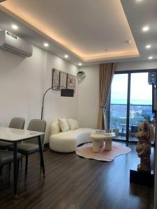 a living room with a white couch and a table at X-Stay Sweet in An Khê