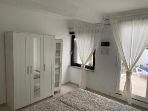 a bedroom with white curtains and a large window at Ferienwohnung Luna in Charco del Palo