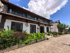 丽江馨舍精品客栈的一座前面有植物的建筑物