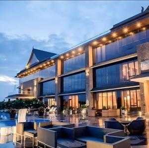 Un edificio con sillas y mesas delante. en Rio Colina - D Diamond 3BHK Villa in Surat, en Dighas