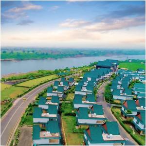 Una vista aérea de una ciudad con casas junto a un río. en Rio Colina - D Diamond 3BHK Villa in Surat, en Dighas