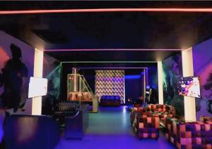 Una habitación con luces violetas y sofás y un escenario. en Rio Colina - D Diamond 3BHK Villa in Surat, en Dighas 26 fotos más