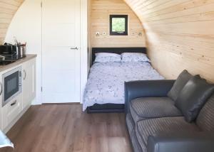 a small bedroom with a bed and a couch at Bron Eifion Lodges in Criccieth