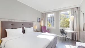 a hotel room with a large bed and a table at Radisson Blu Hotel Bremen in Bremen