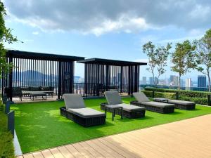 a patio with couches and chairs on the grass at Georgetown#Beacon Executive Suite SkyPool#Luxury&Glamorous Suite#2BR#Living Room with Queen Bed in George Town