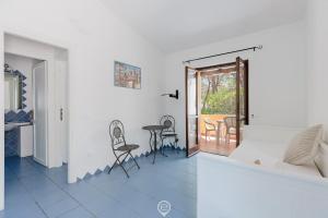 ein Wohnzimmer mit Tisch und Stühlen und einem Balkon in der Unterkunft Malva Beach Apartment in Fort Village