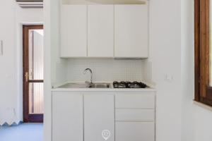 eine Küche mit weißen Schränken und einer Spüle in der Unterkunft Malva Beach Apartment in Fort Village