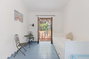 Zimmer mit Tür, Tisch und Stühlen in der Unterkunft Malva Beach Apartment in Fort Village