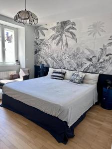 ein Schlafzimmer mit einem großen Bett und einer tropischen Tapete in der Unterkunft Agréable maison de ville avec terrasse et garage in Saint-Affrique