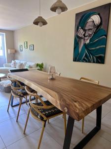 einen Holztisch im Wohnzimmer mit einem Gemälde in der Unterkunft Agréable maison de ville avec terrasse et garage in Saint-Affrique + 17 Fotos