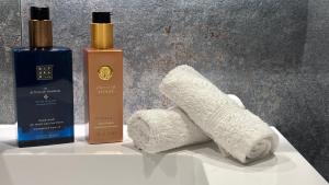 three bottles of soap and towels on a table at Luxury City Cottage in Rovaniemi