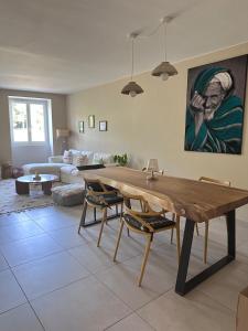 ein Wohnzimmer mit Tisch und Couch in der Unterkunft Agréable maison de ville avec terrasse et garage in Saint-Affrique