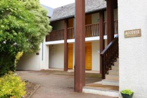 ein Gebäude mit orangefarbenen und gelben Türen und Treppen in der Unterkunft Auberge de la Vallée d'Ossau in Izest + 1 Foto