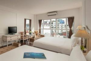 Una habitación de hotel con dos camas y un televisor. en Hanoi Traveller House, en Hanói