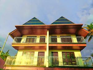 ein gelbes Gebäude mit einem Dach und einem Balkon in der Unterkunft Romance Resort Varkala in Varkala + 19 Fotos