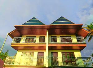 ein gelbes Gebäude mit einem Walmdach in der Unterkunft Romance Resort Varkala in Varkala