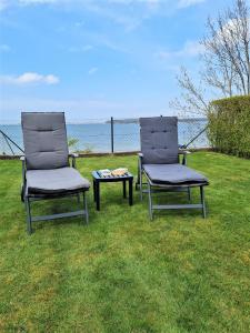 two chairs and a table sitting in the grass at Fh Rügenblick in Stralsund +7 photos